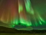 Captivating view of the Aurora Borealis over Reykjahlíð, Iceland's night landscape.