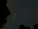 a shooting star is seen in the night sky