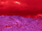 A red and purple sky over a mountain range