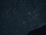 the night sky with stars moving across the sky