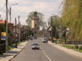A scenic street view featuring a church and residential buildings in a Polish town. Ideal for travel and architecture themes.