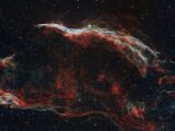 Explore the vibrant colors and patterns of the Veil Nebula captured in deep space.