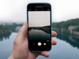 person taking photo of body of water