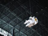 Astronaut model suspended within the Chantilly Air and Space Museum exhibit showcasing space exploration history.