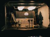 A creative diorama depicting the moon landing with astronauts and flag in a studio setup.