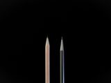 A clean, minimalist shot showcasing a traditional pencil and a mechanical pencil against a black background.