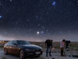 a couple of people standing next to a car