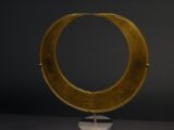 a sculpture of a circular object on a stand