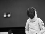 a person wearing a white jacket and a black hat