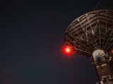 a radio tower with a red light on top of it