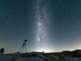 black tripod on snow covered ground under starry night
