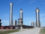 Starship prototypes standing tall at Brownsville, Texas launch site under clear skies.