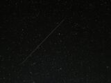 Captivating starry night sky with a visible shooting star streaking across the cosmic backdrop.