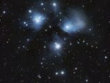 Capture of the Pleiades star cluster with surrounding stars in a clear night sky.