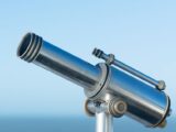 A sleek metallic coin-operated telescope pointing into a clear blue sky, perfect day for sightseeing.