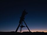 Silhouette of a telescope against a twilight sky, perfect for astronomy enthusiasts.