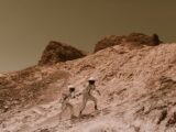 Two astronauts exploring a barren, alien landscape, resembling Mars.