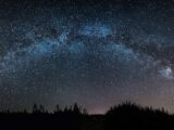 the night sky is filled with stars and trees