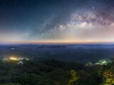 Captivating view of the Milky Way over Tambon Ton Yuan's lush landscape at night.